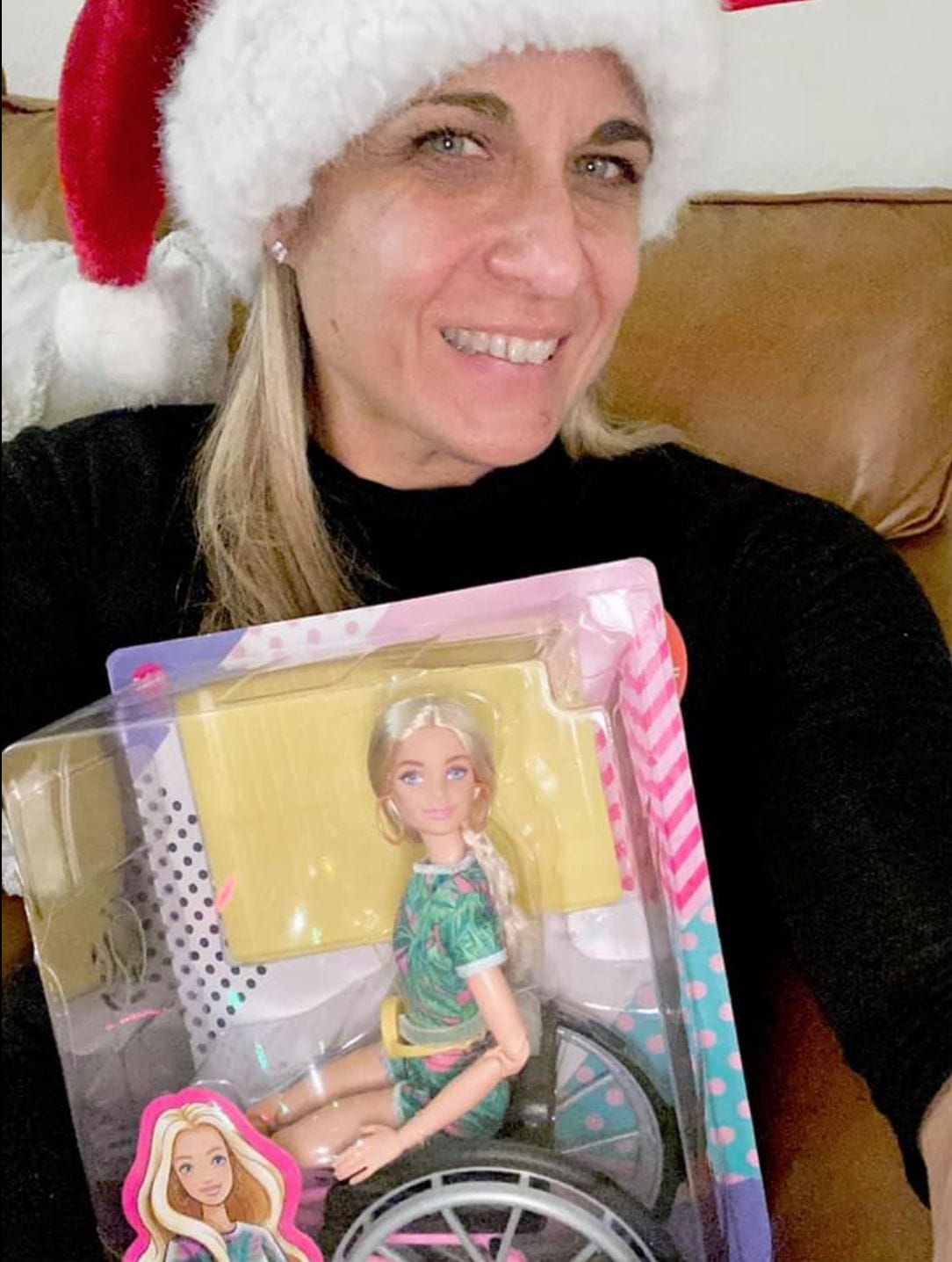 alycia unwrapping a christmas present of barbie doll in a wheelchair