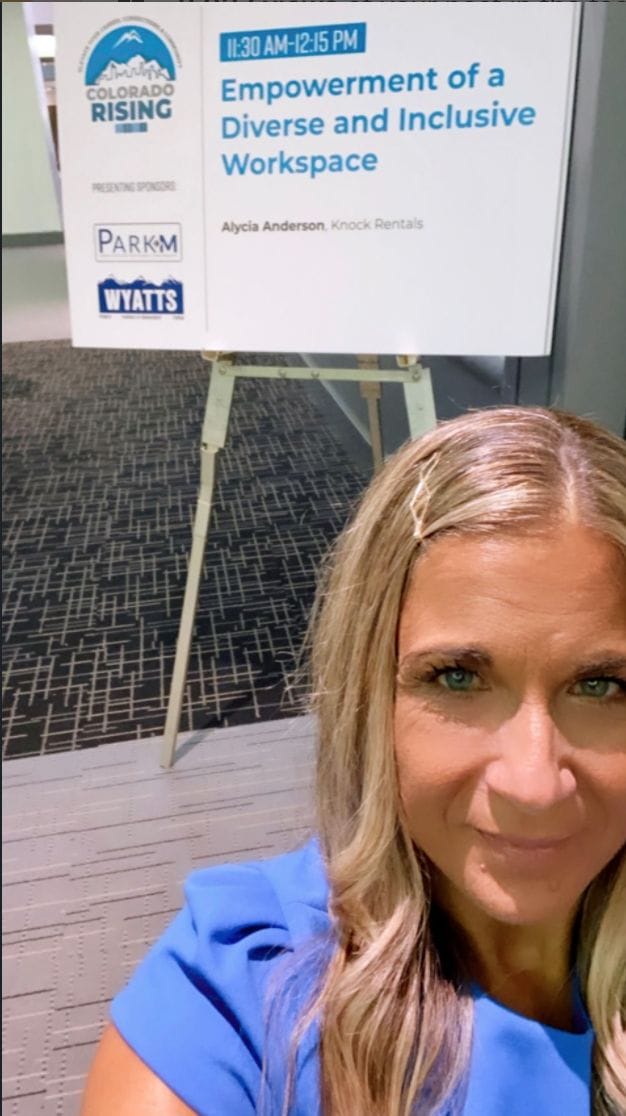 alycia in front of the queue card announcing her as speaker at the colorado rising conference speaking about empowerment of a diverse and inclusive workspace