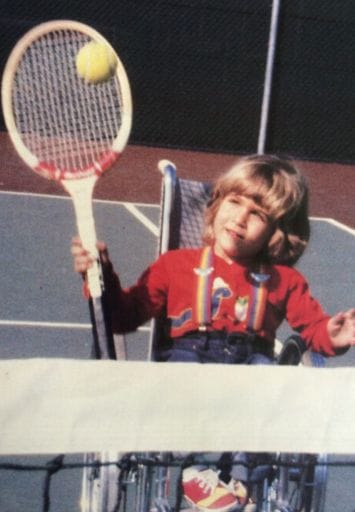 very young alycia hitting a ball with her tennis racquet over a net