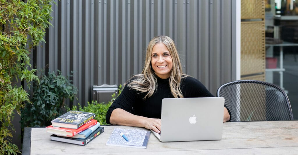 alycia sitting a table with computer and books