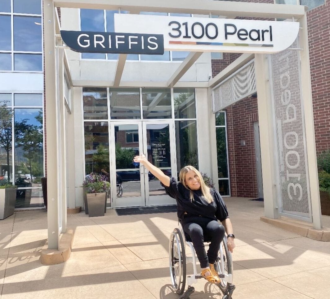 alycia out front of grifis residential thirty one hundred property waiving her hand up to the signage