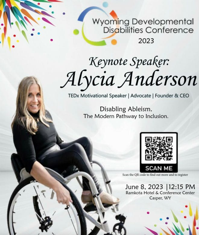 Alycia wearing all black popping a wheelie in her wheelchair in an advertisement for Wyoming Developmental Disabilities Conference on June 8th.