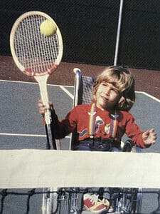 alycia holding a tennis racquet on the courts at four years old