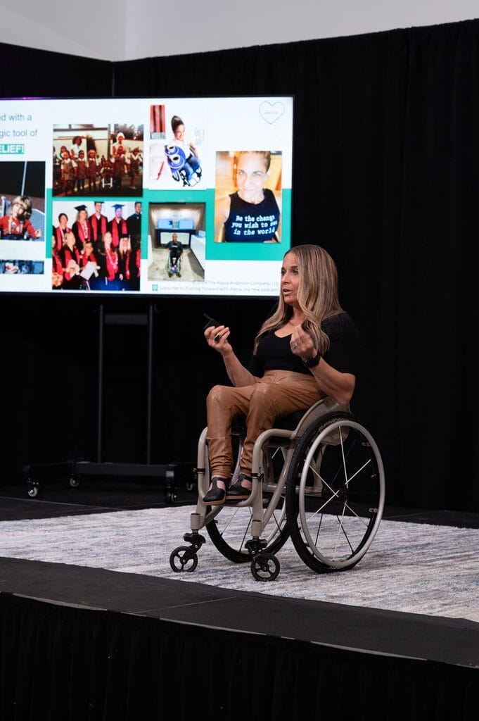alycia on stage in front of monitor with her presentation slides behind her at the humana international womens day event