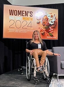 alycia on stage in front of monitor that says womens history month twenty twenty four women who advocate for diversity equity and inclusion