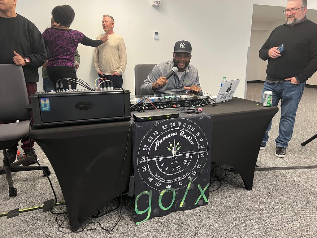 d j reggie mixing up the tunes at humana international womens day event with turntable and audio equipment