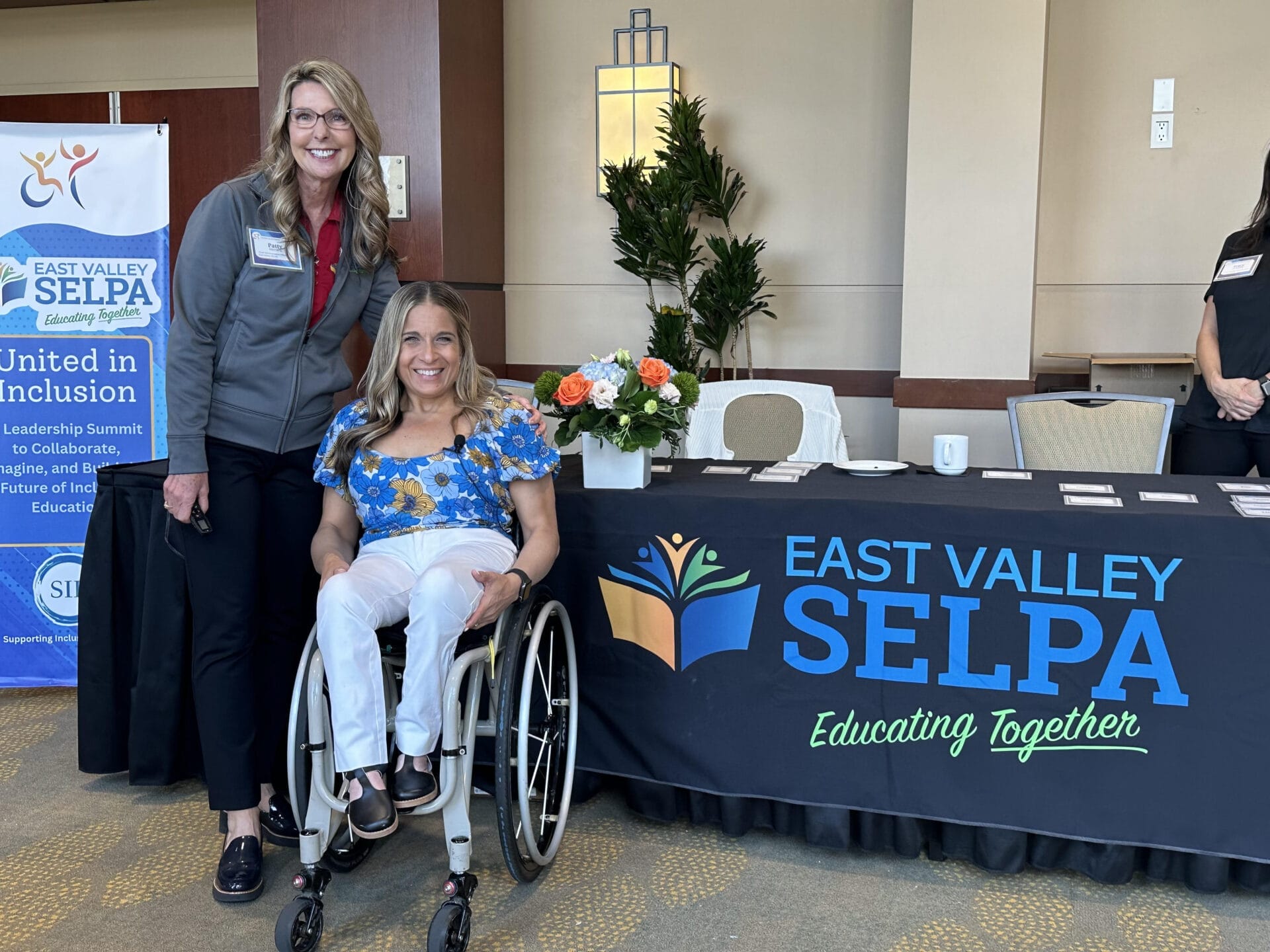 alycia sitting with patty metheny at welcome desk for east valley selpa inclusion summit conference