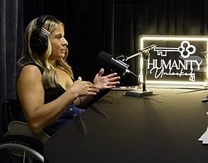 alycia anderson sitting at interview table with humanity unlocked light and microphone and headset
