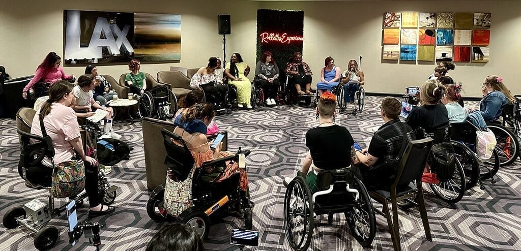 alycia talking to teens in their wheelchairs gathered in a circle