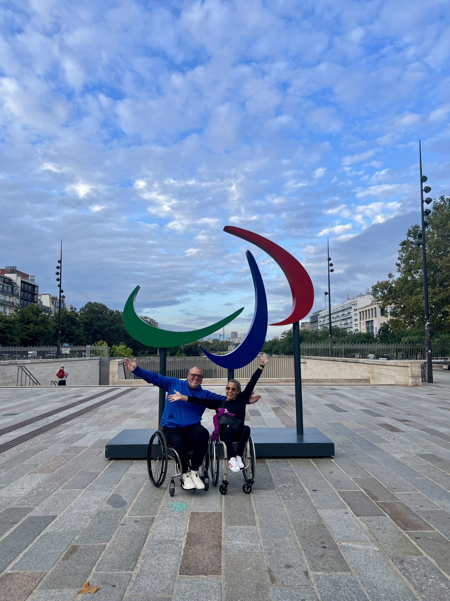 marty and alycia in front of the paralympics symbol in the place de bastille in paris