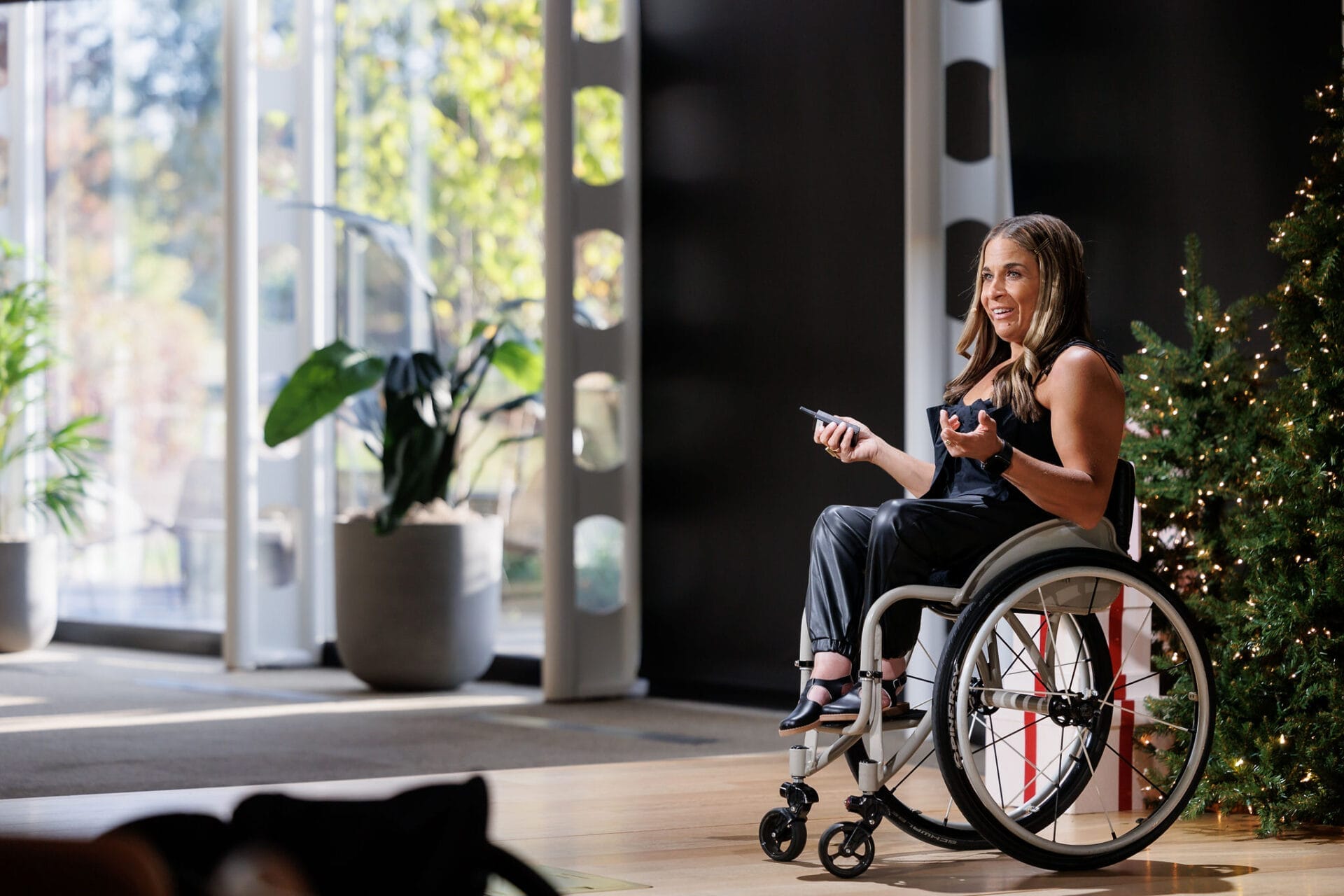 alycia sitting in her wheelchair on stage speaking
