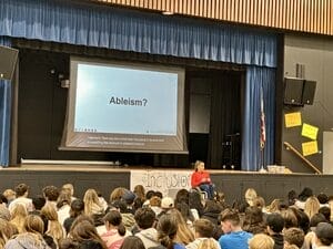 Alycia wearing read speaking to 400 middle school students