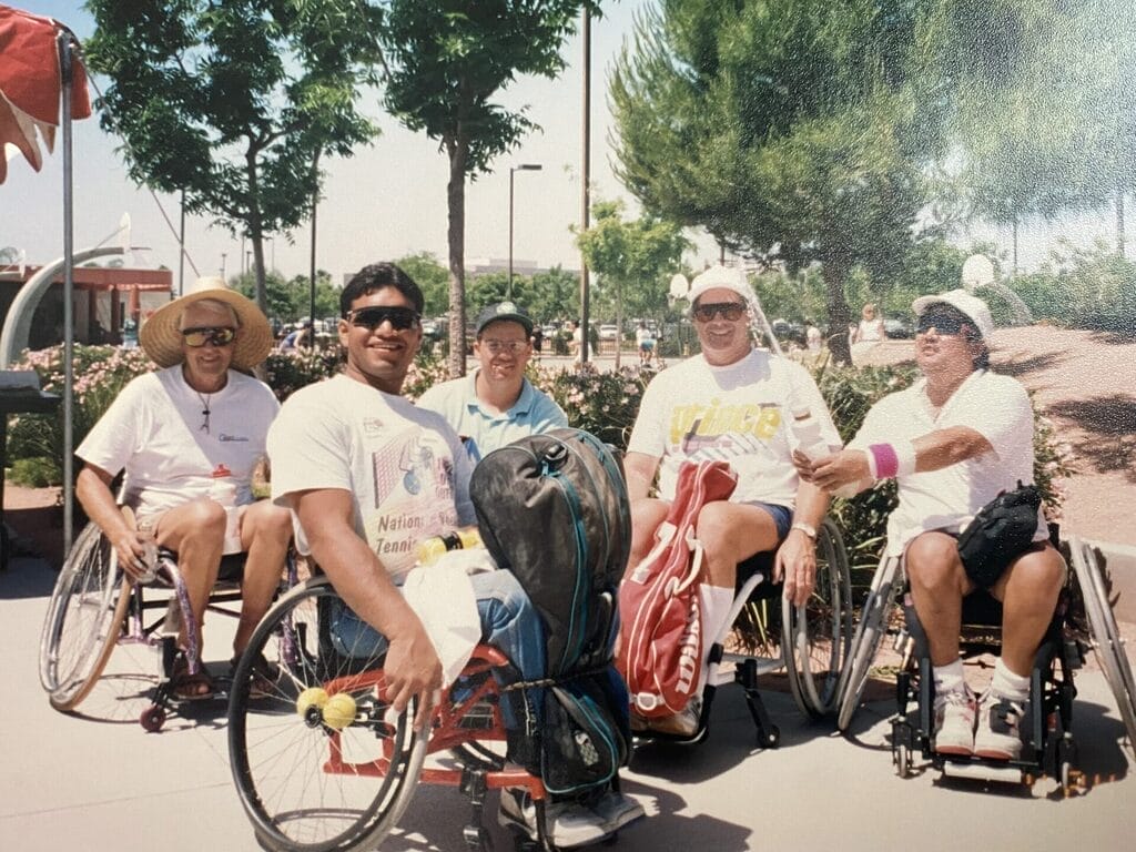 marty as a young adult at a wheelchair tennis tournament with a group of fellow players