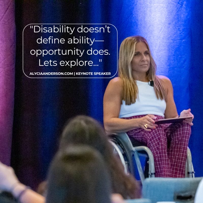 Image description: Alycia sitting in her wheelchair on a panel speaking at a conference wearing a white top and red and blue checked pants looking out at the audience. With a quote that reads "Disability doesn’t define ability—opportunity does. Lets explore..."
