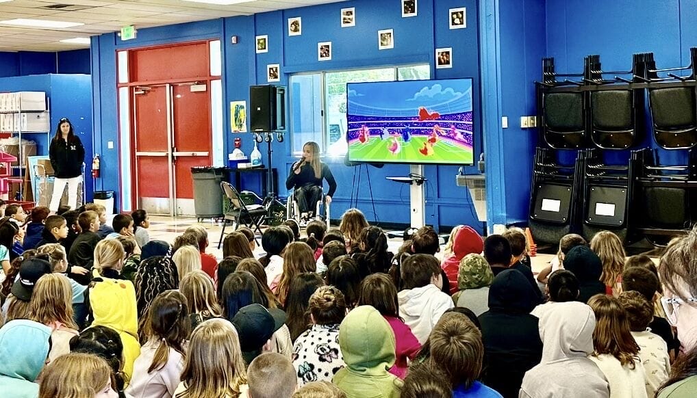 Alycia speaking to a large group of kids