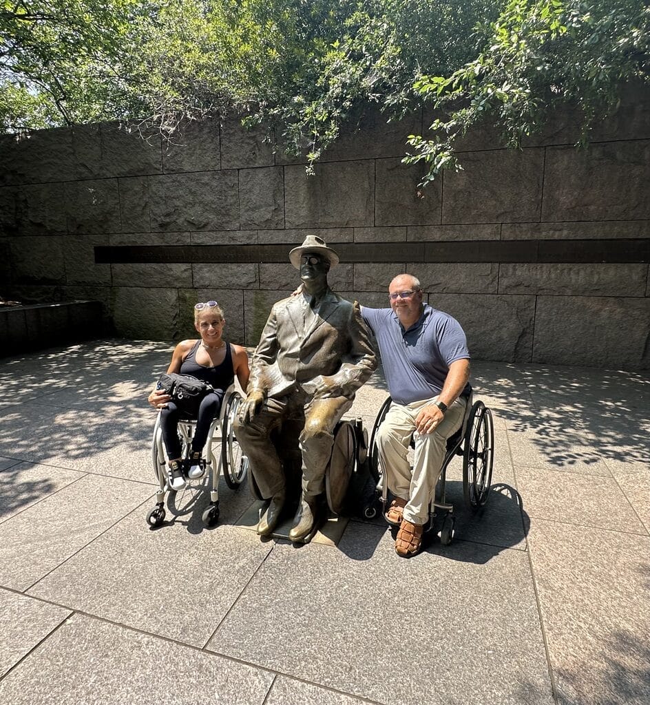 marty and alycia sitting with the statue of fdr in his wheelchair