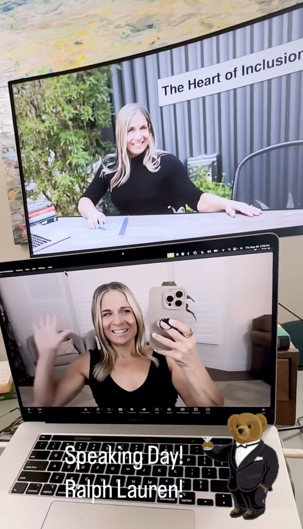 Alycia in selfie video wearing black on her studio in front of two screens giving a keynote.