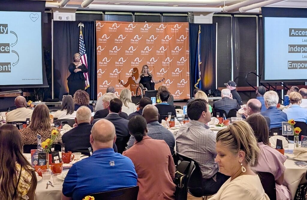 Alycia speaking in front of large group