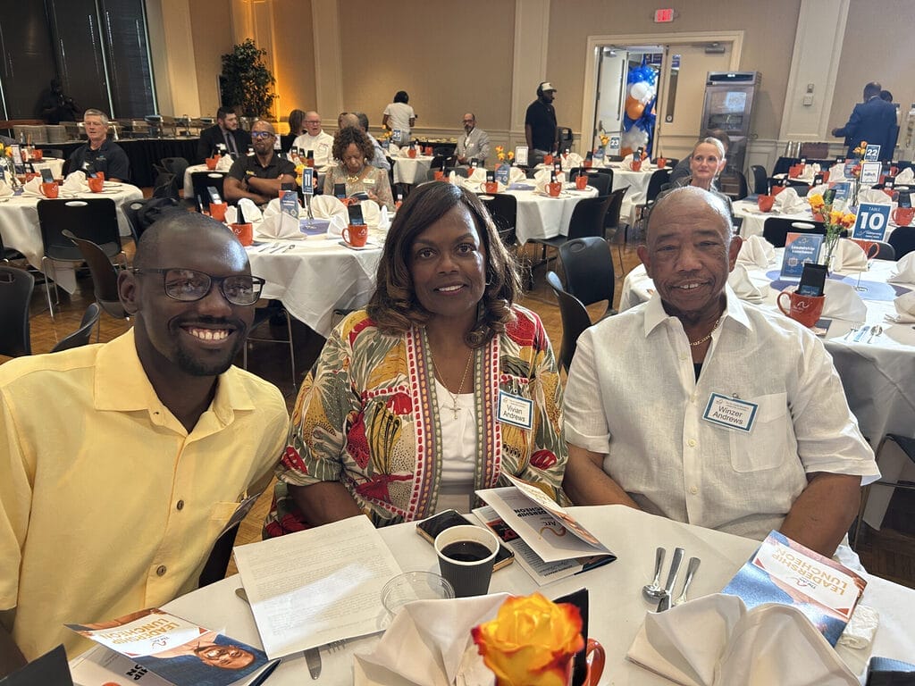 brandon vivian and winzer andrews sitting at the guest tables in the audience