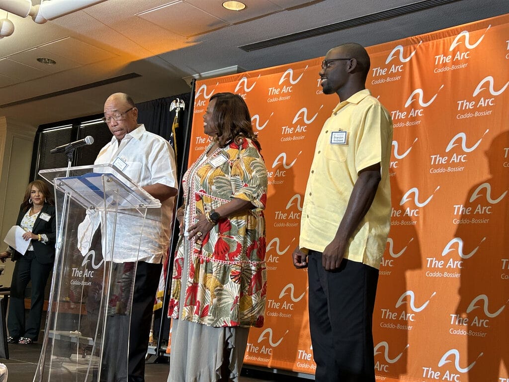 brandon vivian and winzer andrews standing on stage speaking to the crowd