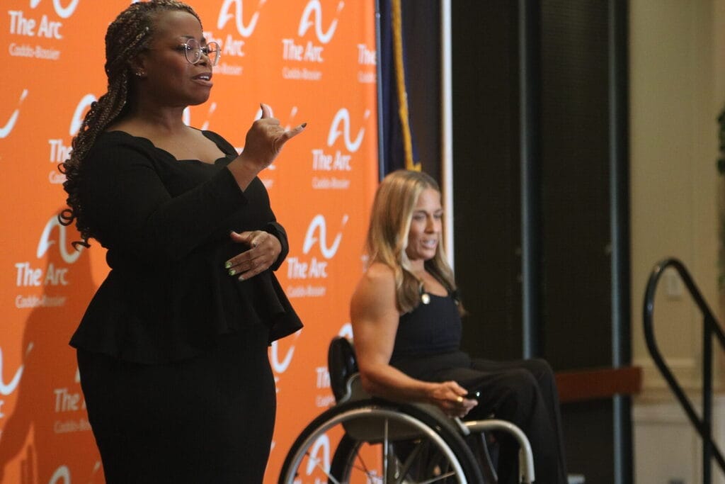a s l interpreter signs on stage with alycia speaking behind her
