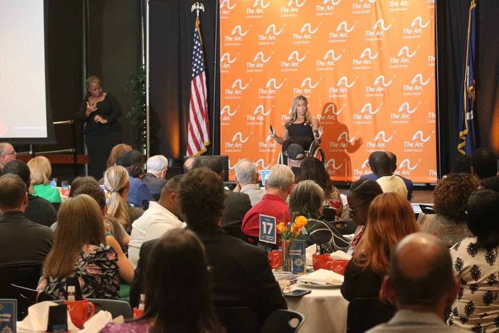 alycia on stage at the arc caddo bossier leadership luncheon on l s u s campus