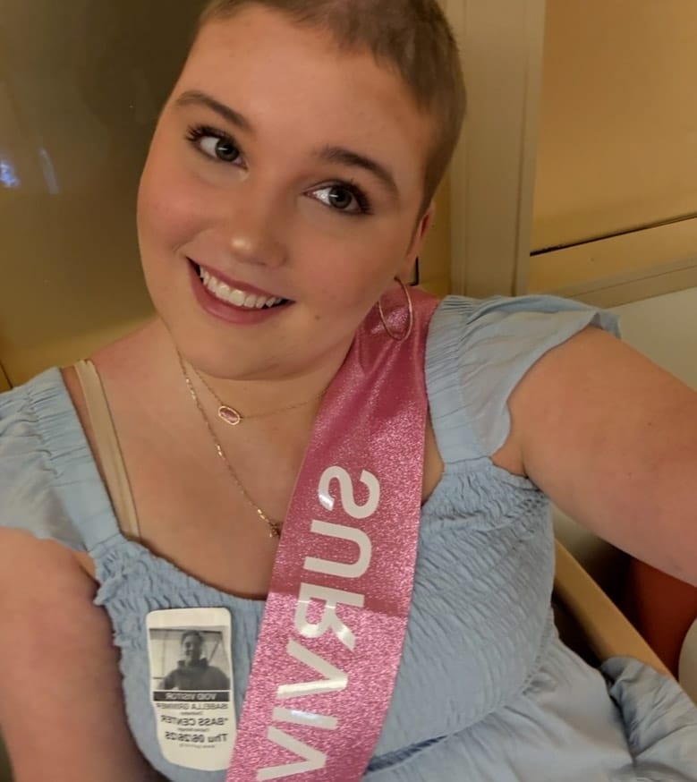 isabella izzy grimmer wearing a sash that says survivor
