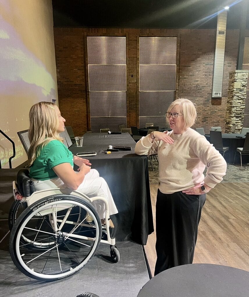 Alycia speaking with an audience member on stage after the event.
