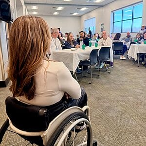 alycia sitting in her wheelchair looking at the crowd she is about to spek to at special olympics virginia fitness collaborative